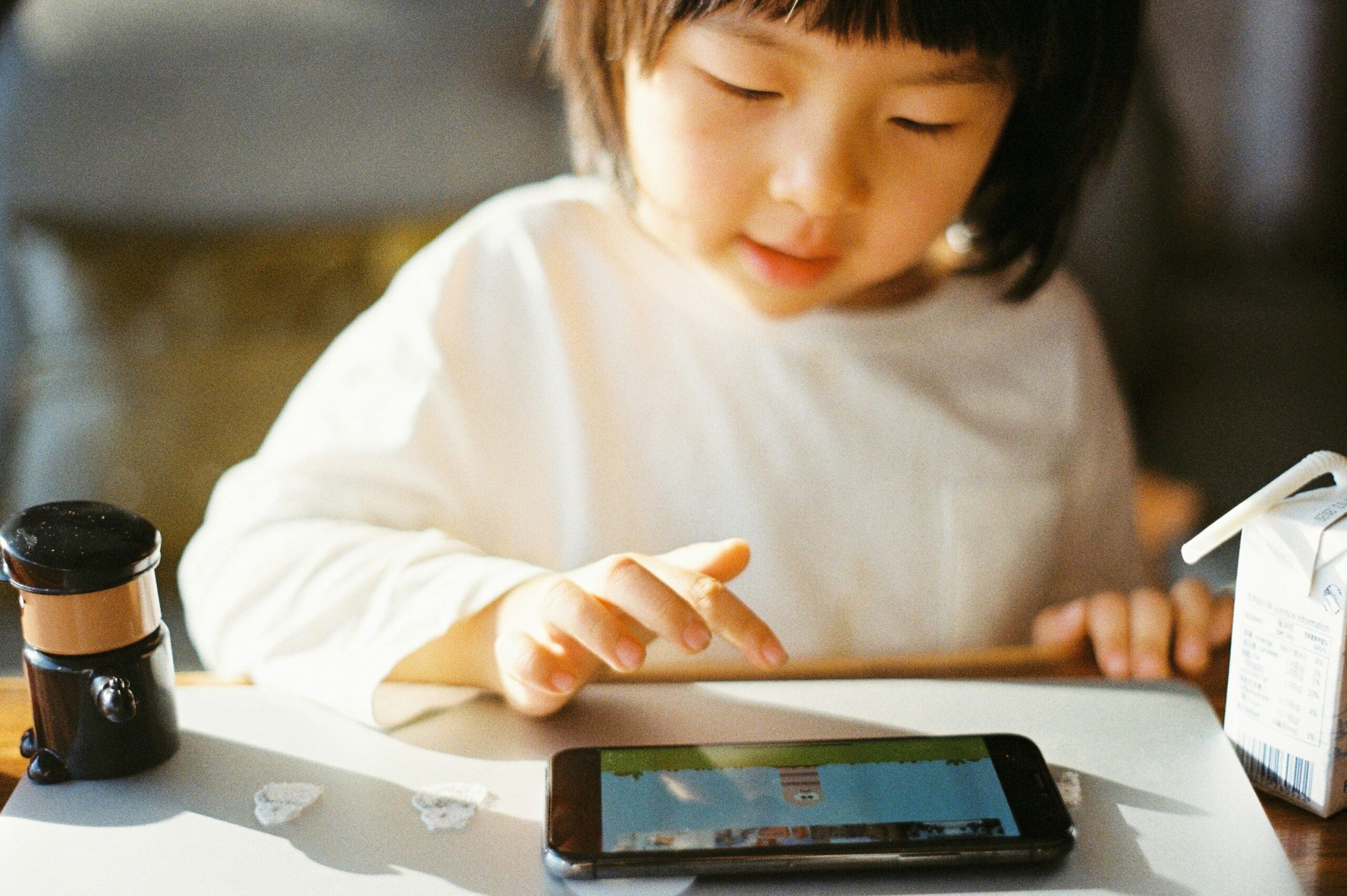 A smiling child holding a tablet displaying a dyslexia app interface