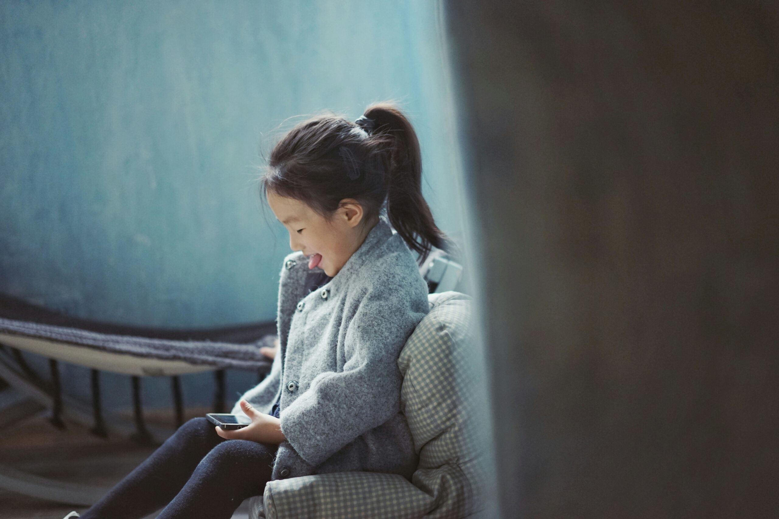 A teenager smiling while using a dyslexia app on a tablet