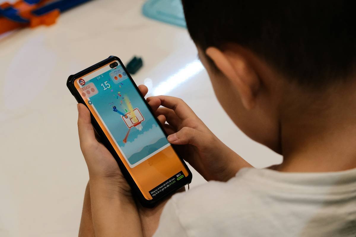 a young boy playing a game on a cell phone