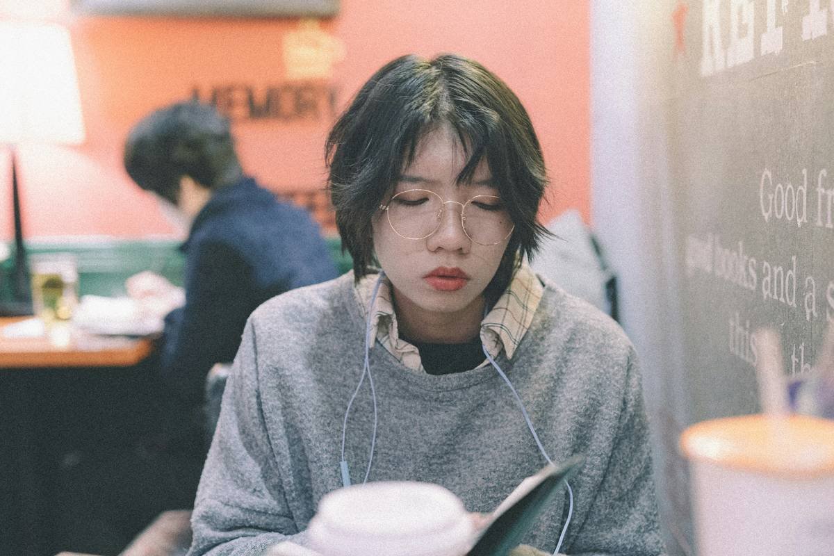 woman sitting in front of gray pitcher